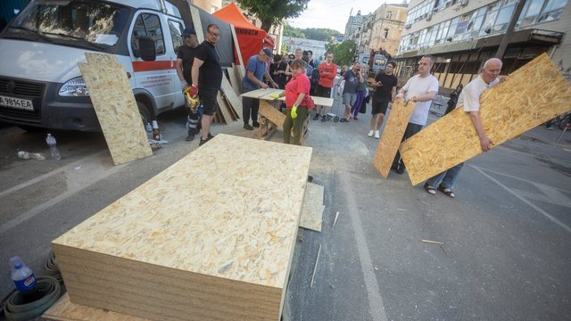 Репортаж: На місцях ударів в Києві тривають відновлювальні роботи, вибиті шибки закриті дошками, більшість бізнесів працює