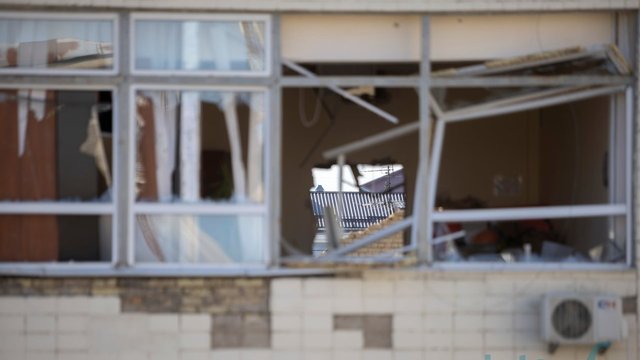 Репортаж: На місцях ударів в Києві тривають відновлювальні роботи, вибиті шибки закриті дошками, більшість бізнесів працює